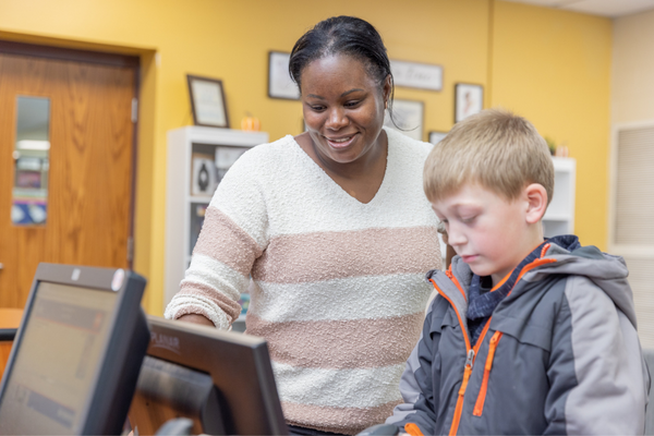 Ms. Velker helping a student check out books